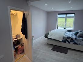 A bedroom with a bed and window at Cherry Chirp Cottage in Enniskillen