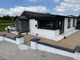 An exterior view of a house with gravel area and planters at Cherry Chirp Cottage Enniskillen