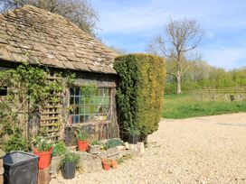 A garden view of a house with plants and gravel pathway at Foxhill Farm Barn in Cheltenham