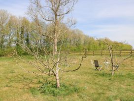 A garden with trees and chairs at Foxhill Farm Barn Cheltenham