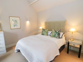 A bedroom with a bed, bedside table, and artwork at Foxhill Farm Barn in Bourton-On-The-Water