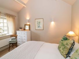 A bedroom featuring a bed with pillows and a dresser at Foxhill Farm Barn in Bourton-On-The-Water