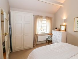 A bedroom with a bed, wardrobe, and window at Foxhill Farm Barn Bourton-On-The-Water