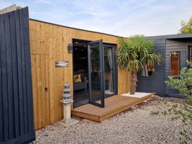 An exterior view of a wooden cabin entrance at Birdsong lodge near Hawthorn Farm near Sutton-On-Sea