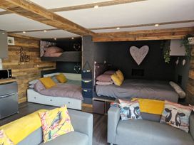 A bedroom with bunk beds and a sofa at Birdsong lodge near Hawthorn Farm near Sutton-On-Sea