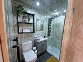 A bathroom with a shower and a vanity at Birdsong lodge near Hawthorn Farm near Sutton-On-Sea