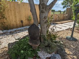 A garden featuring a Buddha statue next to a tree at Birdsong lodge Hawthorn Farm near Sutton-On-Sea