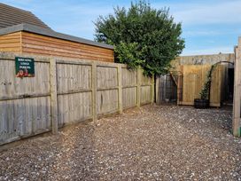 An outdoor parking area with a sign at Birdsong Lodge near Sutton-On-Sea