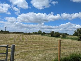 A field with a gate and trees at Birdsong lodge near Hawthorn Farm Sutton-On-Sea