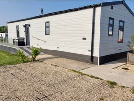 A mobile home with outdoor steps and gravel pathway at Waterside Lodge in Mablethorpe