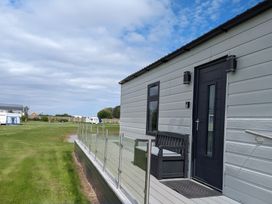 A house with a bench and railing at Waterside Lodge in Mablethorpe