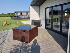 A deck with a table and seating at Waterside Lodge in Mablethorpe