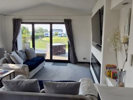 A living room with a TV and sliding doors at Waterside Lodge in Mablethorpe