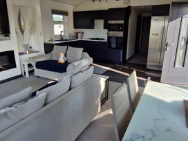 A living room with a sofa and kitchen area at Waterside Lodge in Mablethorpe