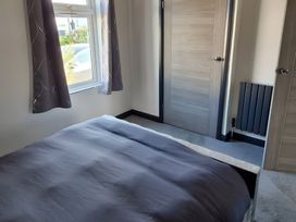 A bedroom with a bed and window at Waterside Lodge in Mablethorpe