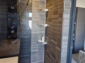 A shower area with a wall panel and shelves at Waterside Lodge in Mablethorpe