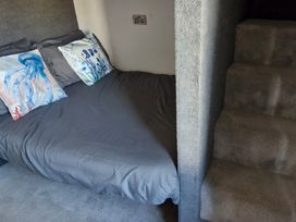 A bedroom with a bed and stairs at Waterside Lodge Mablethorpe