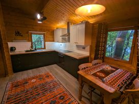 A kitchen with cabinets and a dining table at Pineshadow Lodge in Louth
