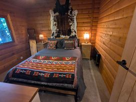 A bedroom with a bed, bedside table and lamp at Pineshadow Lodge in Louth