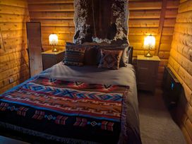 A bedroom with a bed and nightstands at Pineshadow Lodge in Louth