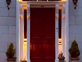 A front entrance with a red door and plants at Fountain Hill House in Londonderry