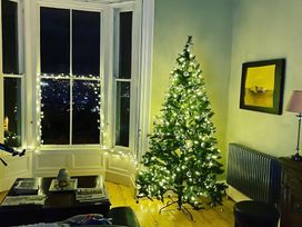 A living room with a Christmas tree and fairy lights at Fountain Hill House Londonderry