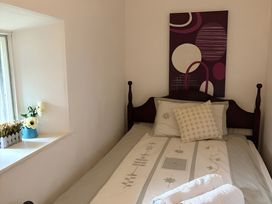 A bedroom with a bed, pillows, flowers and wall decor at Fountain Hill House Londonderry