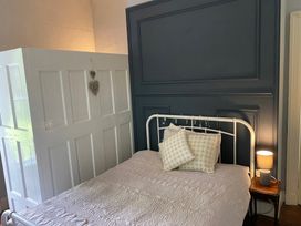 A bedroom with a bed and wardrobe at Fountain Hill House in Londonderry
