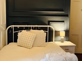 A bedroom with a bed and a lamp at Fountain Hill House in Londonderry