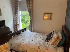 A bedroom with a bed and television at Fountain Hill House in Londonderry