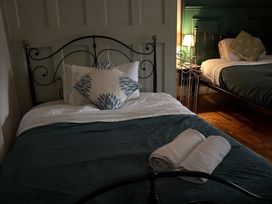 A bedroom with two beds and towels on the first bed at Fountain Hill House Londonderry