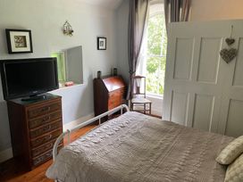 A bedroom with a bed and television at Fountain Hill House Londonderry