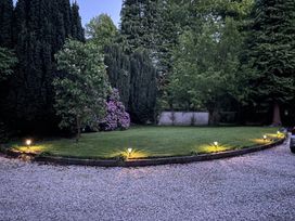 A garden with grass and trees at Fountain Hill House in Londonderry