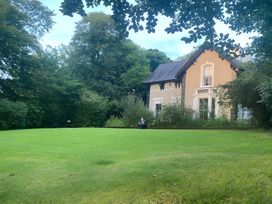 A garden with a house surrounded by grass and trees at Fountain Hill House Londonderry