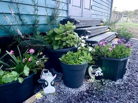 An outdoor area with flower planters and decorations at Bluebell Shepherd's Hut in Llanfairpwllgwyngyll