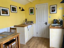 A kitchen with a table and chairs at Bluebell Shepherd’s Hut in Llanfairpwllgwyngyll