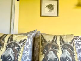A living room with cushions and artwork at Bluebell Shepherd’s Hut in Llanfairpwllgwyngyll
