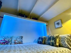 A bedroom with a bed and pillows at Bluebell Shepherd’s Hut in Llanfairpwllgwyngyll