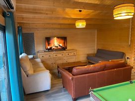 A living room with sofas and pool table at Cotswold Nights in Evesham