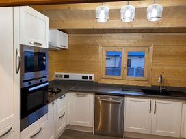 A kitchen featuring an oven, microwave, gas stove, sink, and window at Cotswold Nights in Evesham