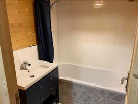 A bathroom with a bathtub and sink at Cotswold Nights Evesham