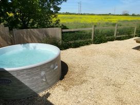 A hot tub in a yard adjacent to a field at Cotswold Nights in Evesham
