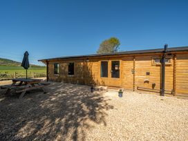 An outdoor area with a wooden cabin and a picnic table at Cotswold Nights Ashton Under Hill