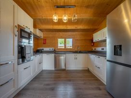 A kitchen with appliances and wooden decor at Cotswold Nights Ashton Under Hill