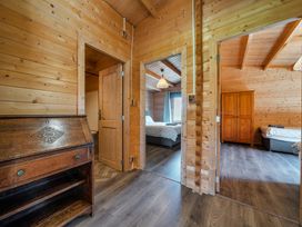 An interior view of a wooden bedroom with doors and furniture at Cotswold Nights Ashton Under Hill