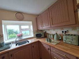 A kitchen with a sink and appliances at Sea view cottage in Penmaenmawr