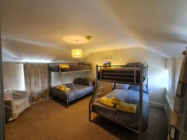 A bedroom with bunk beds and a couch at Sea view cottage in Penmaenmawr
