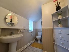 A bathroom with a sink, toilet, and shelf at Sea view cottage, Penmaenmawr