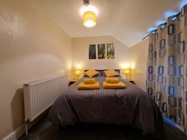 A bedroom with a bed, pillows, and towels at Sea view cottage Penmaenmawr