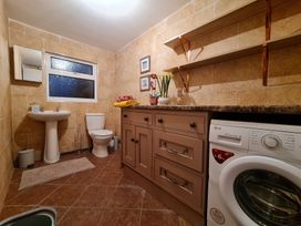 A bathroom with a sink, toilet, and washing machine at Sea view cottage Penmaenmawr